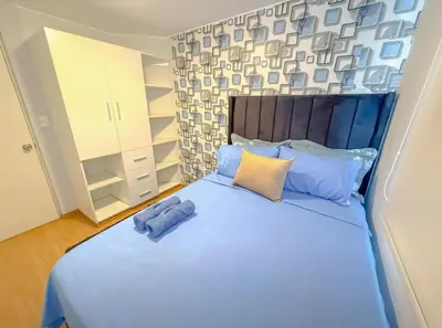 a bedroom with a large bed with blue pillows at Modern XXL Apartment in San Miguel in Lima