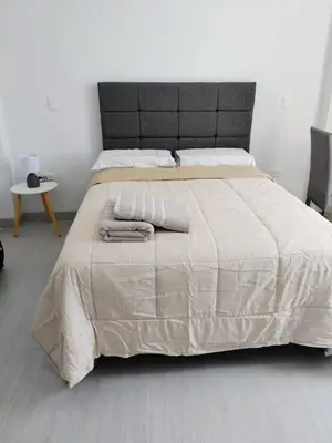 a bedroom with a large bed with two towels on it at Habitacion Matrimonial con Baño Privado Entrada Independiente in Ica
