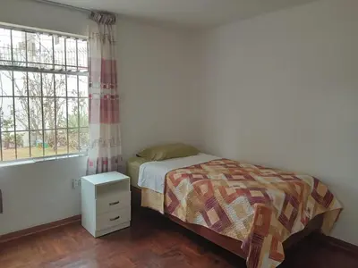a small bedroom with a bed and a window at KUSIHaus due in Lima