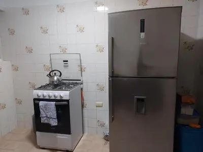 a kitchen with a stainless steel refrigerator and a stove at KUSIHaus due in Lima