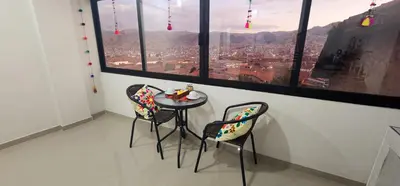 a table and chairs in a room with a view at Vistas increíbles desde San Blas 4 in Cusco