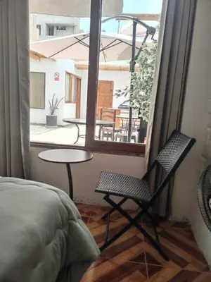 a room with a bed and a table and a window at Hospedaje Vientos in Paracas