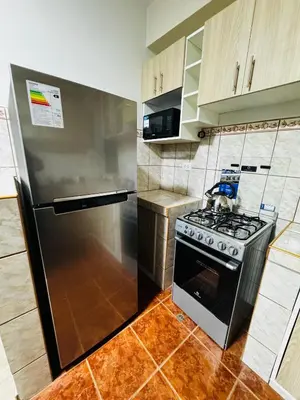 a kitchen with a stove and a refrigerator at Aitanas House Huancaro in Cusco