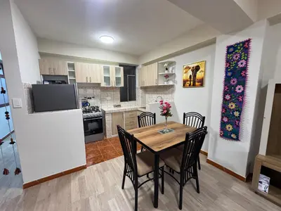 a kitchen and dining room with a table and chairs at Aitanas House Huancaro in Cusco