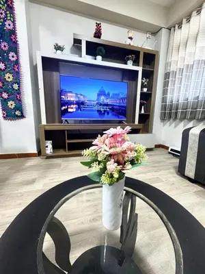 a living room with a vase with flowers on a table at Aitanas House Huancaro in Cusco