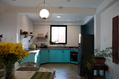 a kitchen with blue cabinets and a table and a window at Casa Julia in Huayllabamba