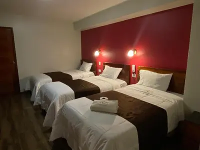 a group of four beds in a hotel room at Hotel Sonccollay in Huancayo