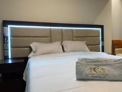 a bedroom with a large bed with a large headboard at Hotel Sonccollay in Huancayo