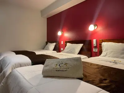 a hotel room with three beds in a room at Hotel Sonccollay in Huancayo