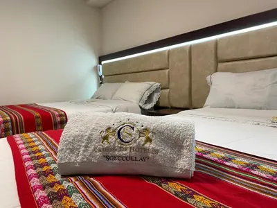 a hotel room with two beds and a blanket at Hotel Sonccollay in Huancayo