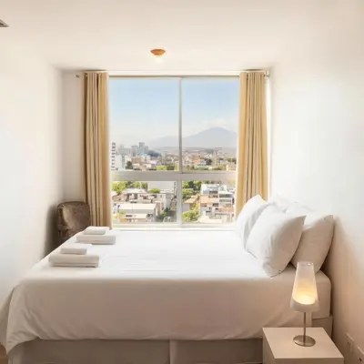 a bedroom with a large white bed and a large window at E24h Modern Executive Loft 2BR 1401 in Lima