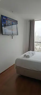 a bedroom with a bed with a tv on the wall at E24h Modern Executive Loft 2BR 1401 in Lima