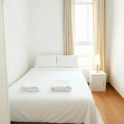 a white bed in a room with a window at E24h Modern Executive Loft 2BR 1401 in Lima