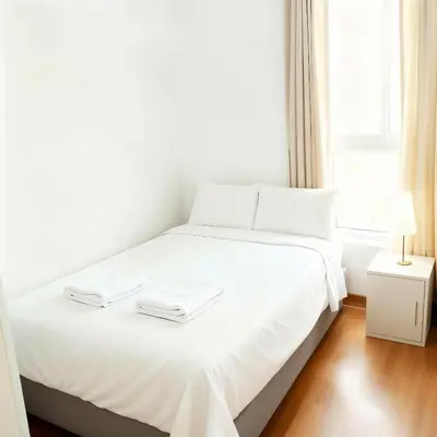 a white bed in a room with a window at E24h Modern Executive Loft 2BR 1401 in Lima