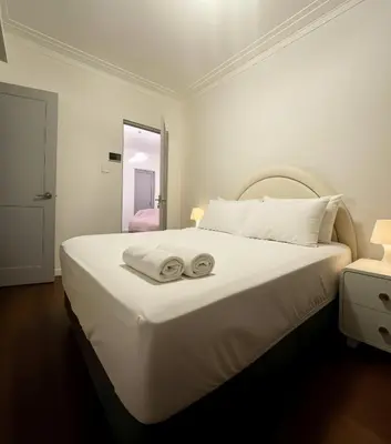 a white bedroom with a large bed with two towels on it at E LidiaHome Boutique Room Miraflores Wifi Pro 1B in Lima