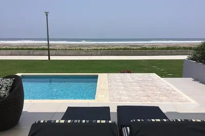 a swimming pool with chairs next to a beach at Casa de playa 1era fila cala del mar in Salitre