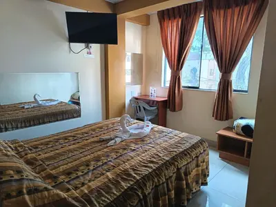 a hotel room with two beds and a mirror at Hostal Winya in Lima