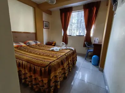 a bedroom with a bed and a desk and a window at Hostal Winya in Lima