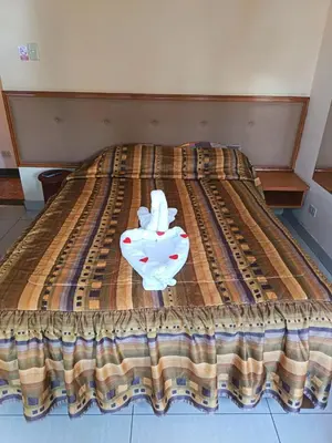 a bed with a bedspread with a white object on it at Hostal Winya in Lima