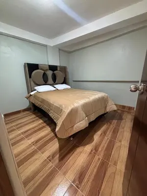 a bedroom with a bed and a wooden floor at Hogar Mesco in Cusco