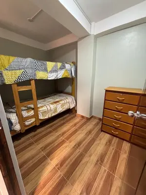 a bedroom with two bunk beds and a wooden floor at Hogar Mesco in Cusco