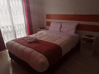 a bedroom with a large bed with a red blanket at Belys inn in Cusco