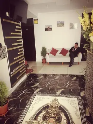 a man sitting on a couch in a living room at Belys inn in Cusco
