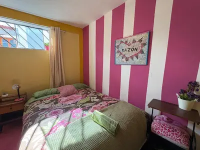 a bedroom with a bed with pink and white stripes at super cute affordable mini apt, san Blas in Cusco
