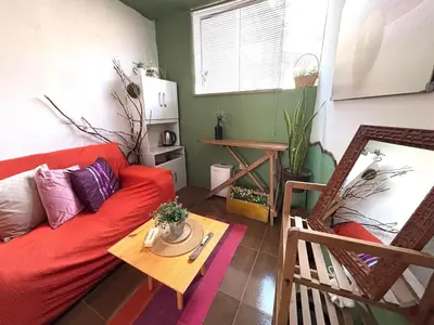 a living room with a red couch and a table at super cute affordable mini apt, san Blas in Cusco