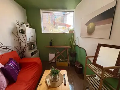 a living room with a red couch and a table at super cute affordable mini apt, san Blas in Cusco