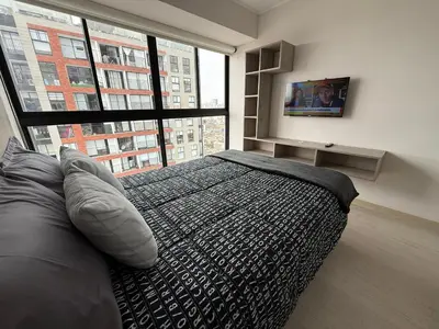 a bedroom with a bed and a large window at Departamento Vizuale in Lima