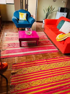 a living room with a red couch and a table at New colorful & artsy home, fam perfect, great wifi for working in Cusco