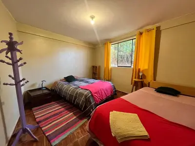 a bedroom with two beds and a window at New colorful & artsy home, fam perfect, great wifi for working in Cusco