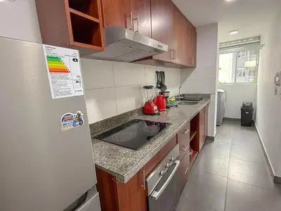 a kitchen with a sink and a refrigerator at Dpto exclusivo en San Miguel con piscina y gym in Lima