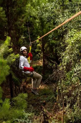 a man on a zip line in the forest at Altares de Oxapampa in Oxapampa