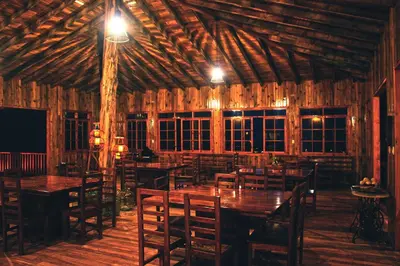 a dining room with wooden tables and chairs at Altares de Oxapampa in Oxapampa