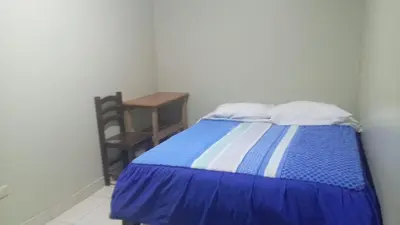 a bedroom with a blue and white bed and a table at Hospedaje El Encanto in Huancayo