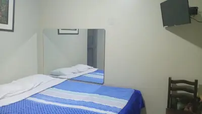 a bedroom with two beds and a mirror at Hospedaje El Encanto in Huancayo