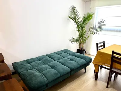a green couch in a living room with a table at Departamento 9 Personas San Isidro in Lima