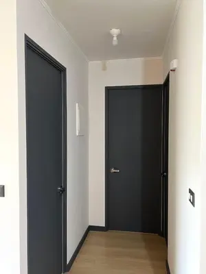 two black doors in a room with wooden floors at Departamento 9 Personas San Isidro in Lima