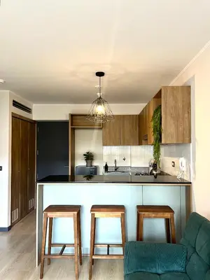 a kitchen with a counter and two stools in a room at Departamento 9 Personas San Isidro in Lima