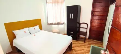 a bedroom with a white bed and a wooden door at Los Pulpos in Bombiso