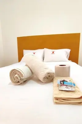 a rolled up towel sitting on top of a bed at Los Pulpos in Bombiso