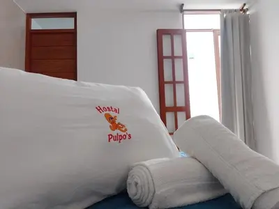 a white bed with a sign on the side of it at Los Pulpos in Bombiso