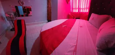 a bedroom with a red and white bed with pink lighting at Hostal Paris 3 Visita Lima con excelente ubicación, wifi gratis y vistas en in Lima