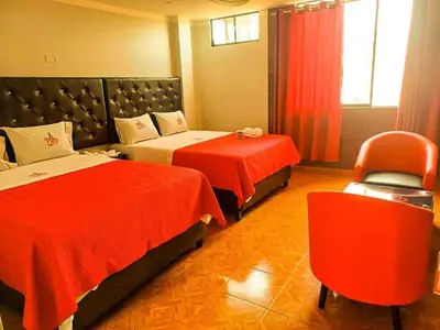 a hotel room with two beds and a chair at Hostal Paris 3 Visita Lima con excelente ubicación, wifi gratis y vistas en in Lima