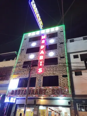 a tall brick building with a neon sign on it at Hostal Paris 3 Visita Lima con excelente ubicación, wifi gratis y vistas en in Lima