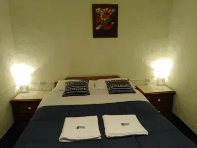 a bedroom with a bed with two lights on it at Casa Margarita in Cusco