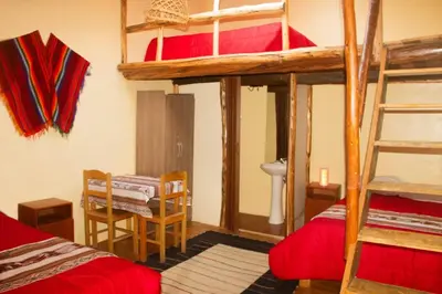 a room with two bunk beds and a table at Casa rústica Pumayalli in Urubamba