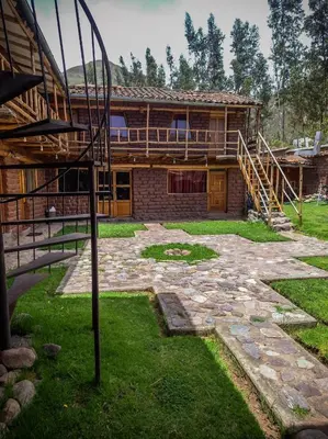 a large house with a stone yard in front of it at Casa rústica Pumayalli in Urubamba